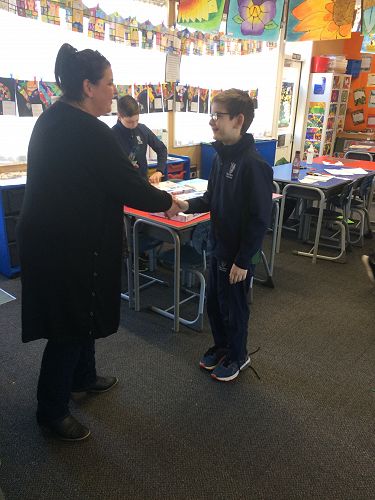 Harrison Bird receiving a Columba pin and special pens