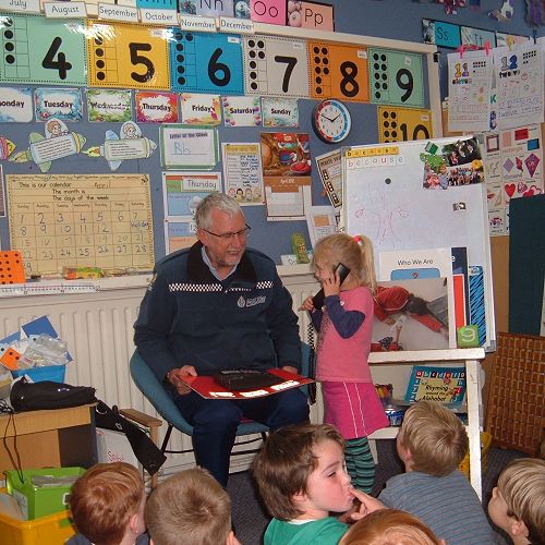Constable Ross teaching Room 8 how to act in an emergency. 