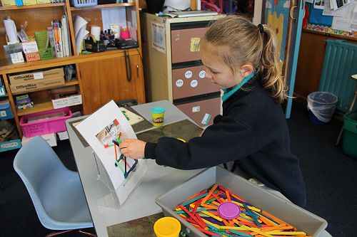 Loretta is planning her 3D shape based on a photo prompt.