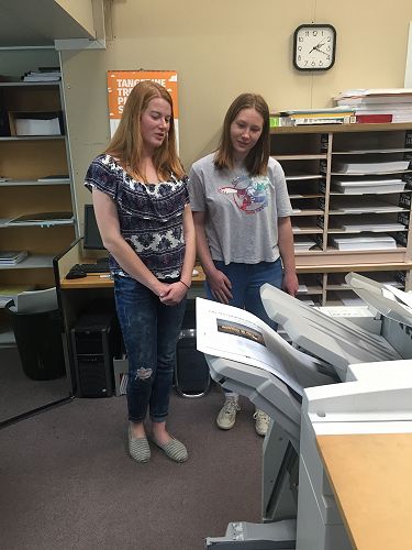 The pair eagerly await the emergence of the first copy.