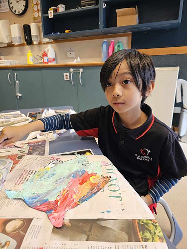 Eli is copying the colour monster picture on the TV screen.