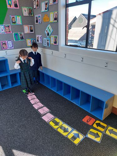 Klara and Penne creating and following coding action cards.