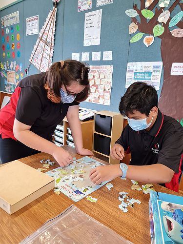 Nicole demonstrates kindness when she helps others complete puzzles.