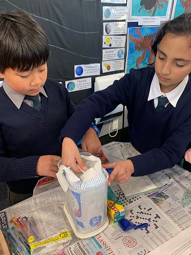 Peter Choi helps Jela Talahma pour flour into the balloon