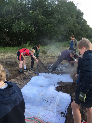 Peeling off the sacks and sheets to reveal the food. Lots of steam meant that we trapped the heat in the ground pretty well.