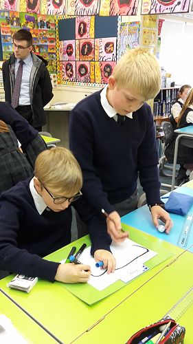 Cohen and Alban drawing their code for their Ozobot