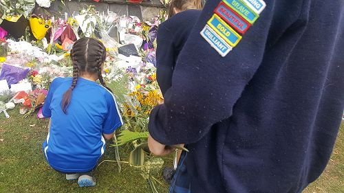 Student leaders leaving flowers at the memorial wall
