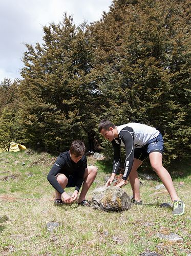Ben Timmings and Jaiden Tucker grab a 'small' rock to hold the tent guy rope down.