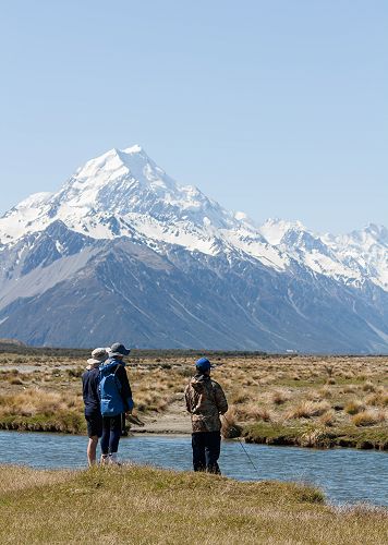 Jin Kim fishes for the elusive Monster trout with Aoraki Mt Cook in the background (and a group of supporters).