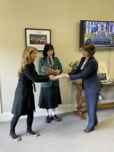Ms Chrystal Gardiner being presented with a gift by Ms Cecilia Madeleine