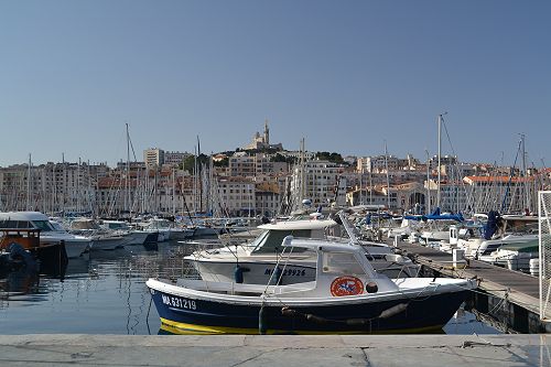 A barque marseillaise berthed in the Vieux Port, Marseille, overlooked by Notre-Dame de la Garde