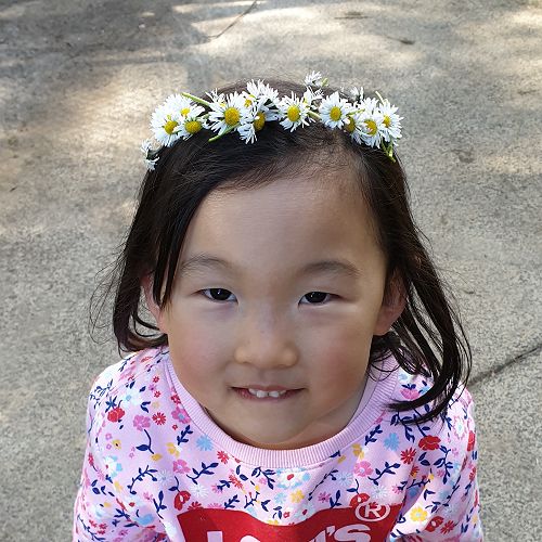 Shania from Room 18 with her lovely Daisy Chain Crown made from the daisies on the big field
