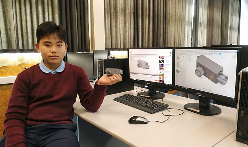 Eunsong holds a part he 3D printed from his model in a CAD/CAM system on the computer