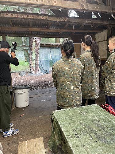 Students attentively learning to fire the paintball gun