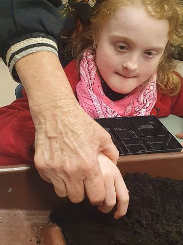 Sophie filling her container ready for seeds.