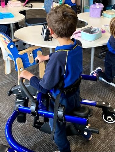 Rylee is trying a walking frame to get around his classroom at Ashgrove.