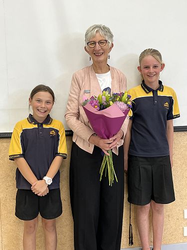 Librarians Penny and Emma present Mrs Ross with flowers.
