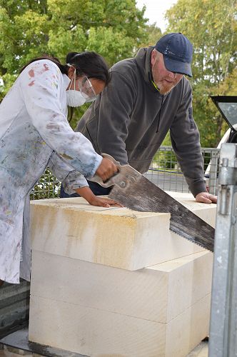 Aaron Smith teaching Heilee how to saw the stone.