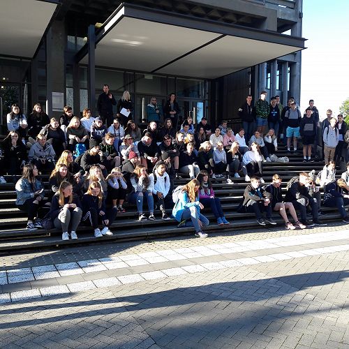 Student's listen to introduction from Canterbury University Staff on the steps of the UC Library Building