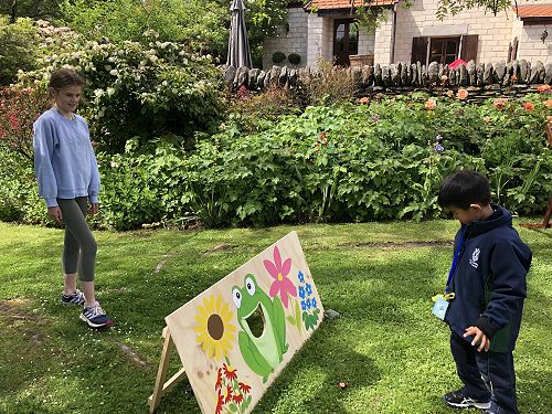 Harriet watching Liam aim for the frog's mouth