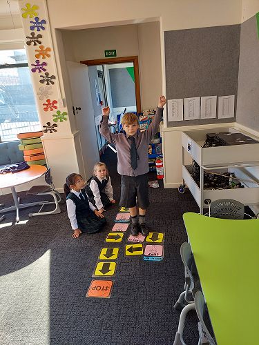 Liliana, Aria and Torran creating and following coding action cards.