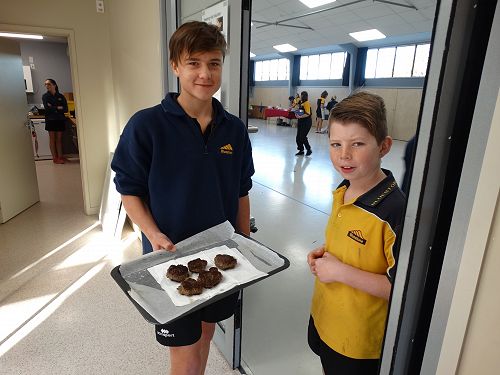 Nick and Connor proudly show their beef patties ready for their burger