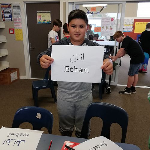 Ethan proudly displays his name written in Farsi. 