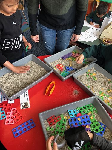 Strengthening our fine motor skills and using them to find the jewels to fit the Numicon.