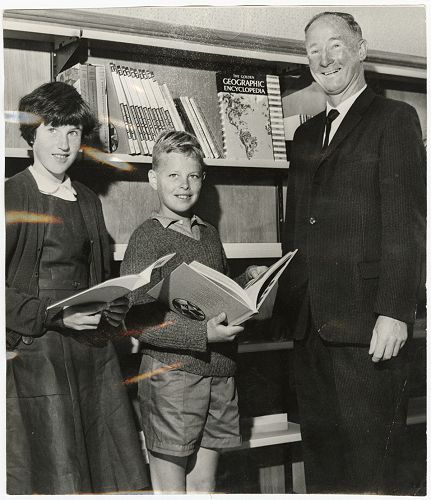 Christine Sheehan (left) and Mark Crump, the first two students on the roll on the opening of Casebrook Intermediate School, with the head teacher Mr G. H. Watson in the school library.