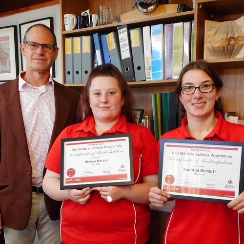 Mr Comeau congratulates Alyssa Haren and Annabel Bartlett on their Red Shirts in Schools success