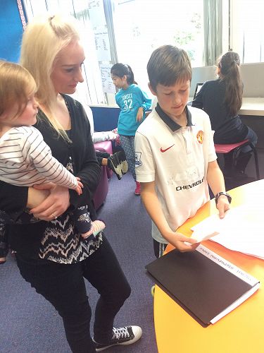 Micah proudly shares his learning with his mum.