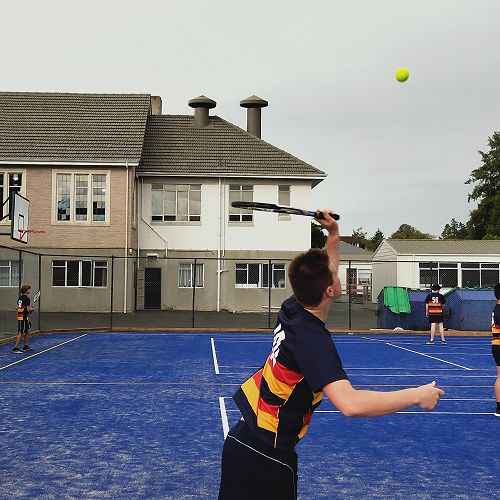 Year 12 PE practicing their non-dominant tennis serve on the new multi purpose surface.