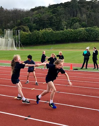 Sam and Isabella mid baton change in the Year 3 and 4 House Relay.