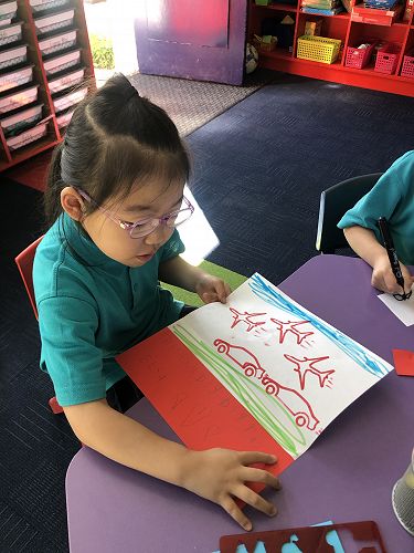 Elsa has used a template to create an image. She then explained about the race between cars and aeroplanes before writing her story.