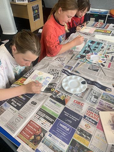 Lara Lowe, Paiyton Dixon and Poppy Hussey paint their tiles.