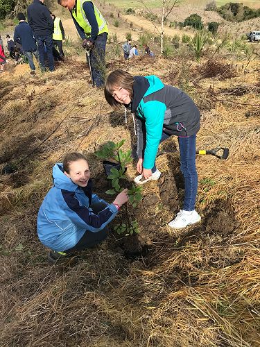 Poppy Henderson and Nora Paicu planting a tree at Walton Park