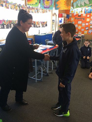Samuel La Hood receiving a Columba pin and special pens