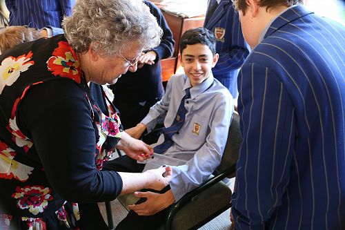 Helen at Middlepark Resthome - teaches sewing a button on with Omar