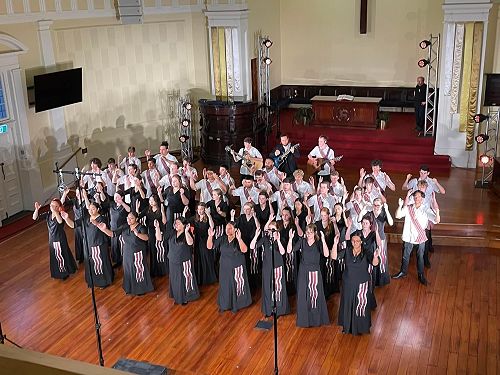 Riley Rolton and choir perform on stage