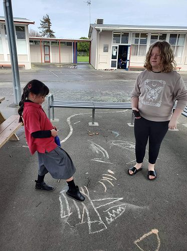 Holly Clark is tuakana helping Olivia Phillips to find and identify the shapes in our scavenger hunt during our KIT day
