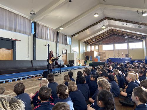 Maevi Fleming singing her Rockquest song for the Sacred Heart Primary students.