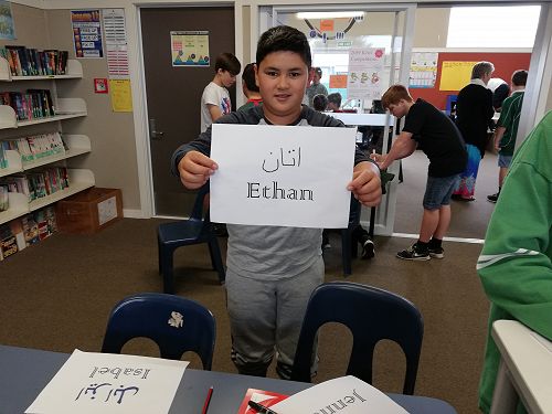 Ethan proudly displays his name written in Farsi. 