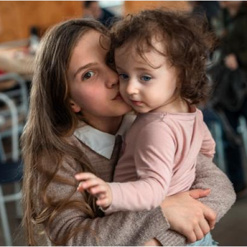 Antonia aged 10 holds her young sister Galyna in a shelter organised by ACT Alliance. They have fled their home in the east of Ukraine and were about to cross the border into Hungary. Names have been changed.