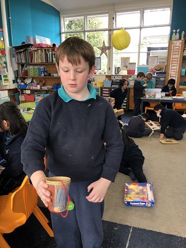 Art Attack challenges change every week, but it is a good opportunity to explore different materials and develop fine motor and planning skills. Rylan has made a cup and pompom challenge. He's trying to catch the pompom in the cup.