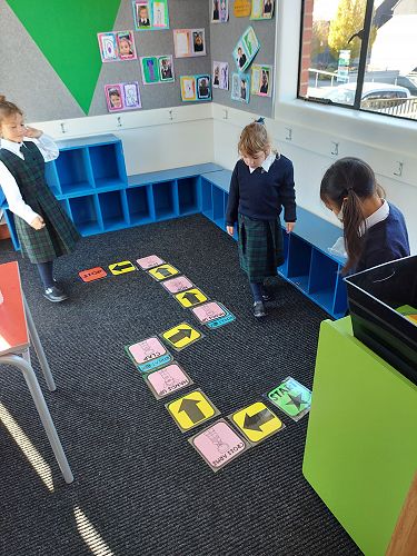 Stella, Carrie and Suliya creating and following coding action cards.