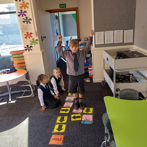 Liliana, Aria and Torran creating and following coding action cards.