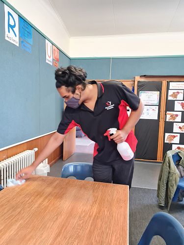 Adi demonstrates kindness by wiping the desk at the end of lunch.