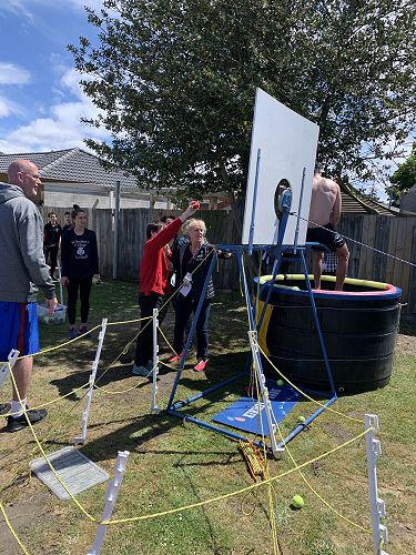 Jayden throwing a ball to knock a StAC helper into the dunk tank.