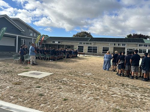 Year 8s and staff waiting on the left as Year 7s, new staff, and families/whānau are seated.