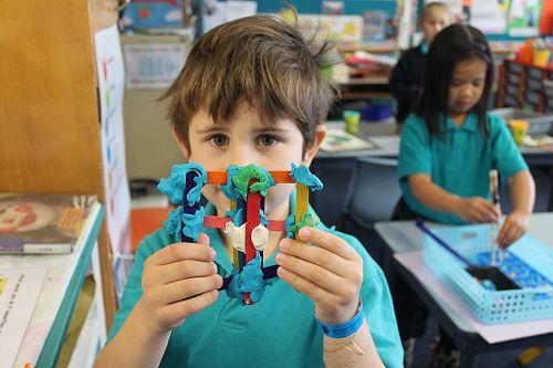 Isaac delighted in creating a shape with popsicle sticks and play dough at the Construction Station.